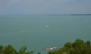 Widok na Balaton z Tihany. Żaglówki na turkusowej wodzie, molo z łodziami. Tihany atrakcje zachwycają.