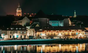 Nocny widok na zabytkowe budynki w Mariborze, Słowenia, z odbiciami świateł w rzece.