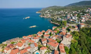 Widok na miasto Ulcinj z lotu ptaka. Czerwone dachy, kamienne budynki i błękitne morze tworzą malowniczy krajobraz. To miejsce pełne atrakcji.