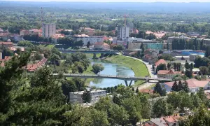 Widok na miasto Karlovac w Chorwacji z rzeką przecinającą krajobraz i mostami łączącymi brzegi.