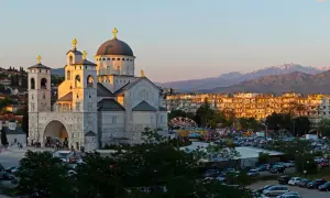 Podgorica atrakcje: monumentalna cerkiew i wesołe miasteczko w blasku zachodzącego słońca.