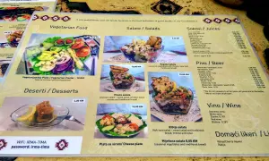 Menu z kuchnią bośniacką: wegetariański talerz, sałatki (w tym szopska), desery, piwo i wino.