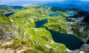 Siedem Rilskich Jezior w górach Pirin, otoczonych zielonymi zboczami i skalistymi szczytami.