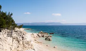 Kamienista plaża z turkusową wodą i schodami prowadzącymi do morza. Idealne miejsce na odkrywanie uroków Chorwacji, Istria atrakcje.