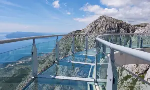 Szklana platforma widokowa z metalową balustradą, z której roztacza się zapierający dech w piersiach widok na morze i góry. To idealne miejsce na spacer po makarska trasa.