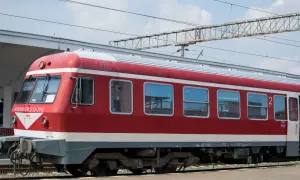 Czerwono-biały pociąg stoi na torach, gotowy do podróży. Czy to właśnie ten pociąg do Bułgarii?
