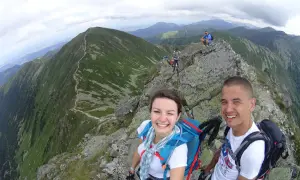 Uśmiechnięci turyści na szczycie w Tatrach Zachodnich Słowacja. Widok na górzyste krajobrazy i szlak.