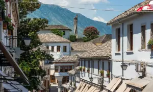 Kamienne dachy i białe domy w Gjirokastrze, Albania. W tle góry, idealne na jesienny spacer.