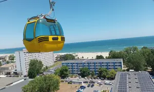 Żółta kolejka linowa nad kurortem z widokiem na piękne **konstanca plaże** i błękitne morze.