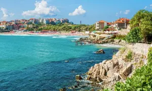 Słoneczne bułgarskie miasta turystyczne nad turkusowym morzem. Widok na plażę, klify i zabudowania.