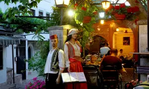 Manekiny w strojach ludowych przed restauracją w Sarajewie. Sprawdzamy sarajewo ceny, by wybrać najlepsze miejsce na posiłek.