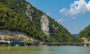 Wielka twarz wyrzeźbiona w skale, symbolizująca Żelazną Bramę, góruje nad rzeką.