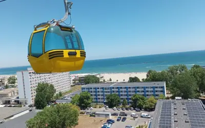 Żółta kolejka linowa nad kurortem z widokiem na piękne **konstanca plaże** i błękitne morze.