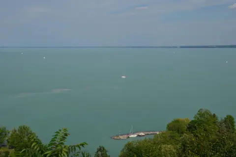 Widok na Balaton z Tihany. Żaglówki na turkusowej wodzie, molo z łodziami. Tihany atrakcje zachwycają.