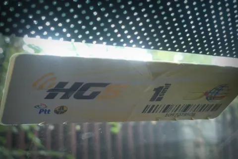 Naklejka na szybę samochodu z napisem "HGS 1. sınıf" i numerem rejestracyjnym. Przygotowania do podróży po Turcji samochodem.