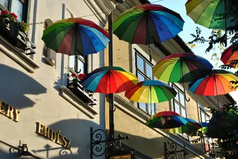Kolorowe parasole unoszą się nad ulicą, tworząc radosną atmosferę. To jedna z urokliwych szentendre atrakcji, która przyciąga wzrok.