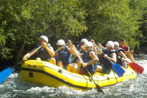 Grupa ludzi na raftingu na rzece Cetina w Chorwacji, wiosłując przez bystrza.