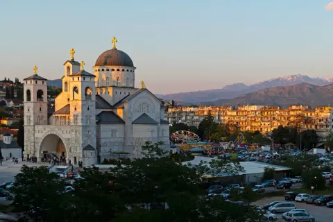Podgorica atrakcje: monumentalna cerkiew i wesołe miasteczko w blasku zachodzącego słońca.