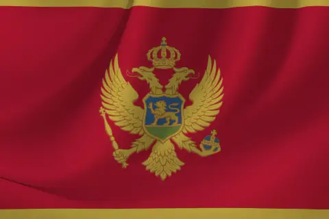 Flaga Czarnogóry z dwugłowym orłem. W tym kraju obowiązuje euro jako waluta, a język urzędowy to czarnogórski.