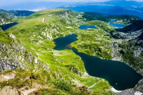 Siedem Rilskich Jezior w górach Pirin, otoczonych zielonymi zboczami i skalistymi szczytami.