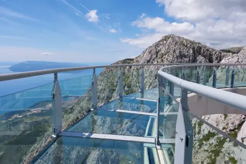 Szklana platforma widokowa z metalową balustradą, z której roztacza się zapierający dech w piersiach widok na morze i góry. To idealne miejsce na spacer po makarska trasa.