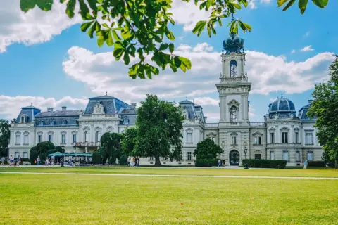 Pałac Festetics w Keszthely, jedna z głównych atrakcji, otoczony zielonym parkiem i błękitnym niebem.