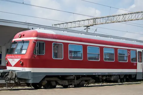 Czerwono-biały pociąg stoi na torach, gotowy do podróży. Czy to właśnie ten pociąg do Bułgarii?