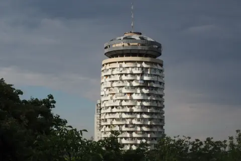 Okrągły wieżowiec z balkonami, przypominający grzyb, to jedna z **kiszyńiów atrakcji**. W tle ciemne chmury.