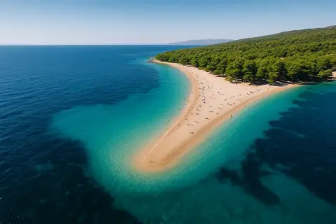 Widok z lotu ptaka na piaszczysty cypel otoczony turkusową wodą. Rajskie plaże z zielonym lasem w tle.