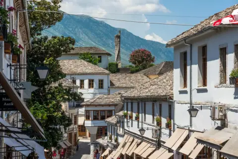 Kamienne dachy i białe domy w Gjirokastrze, Albania. W tle góry, idealne na jesienny spacer.