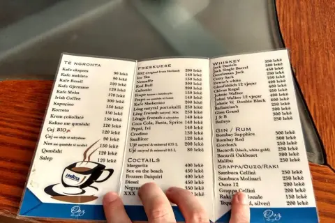 Menu z Albanii: ceny alkoholi. Widoczne są ceny whisky, ginu, rumu, grappy, ouzo i raki.