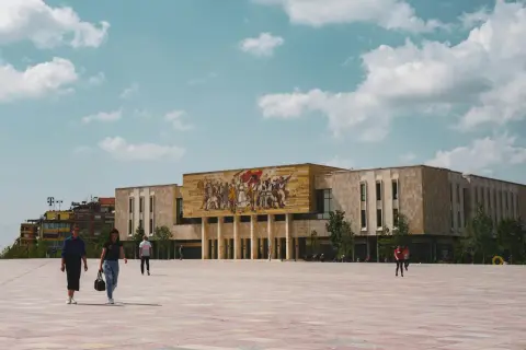 Plac Skanderbega w Tiranie, z monumentalnym budynkiem i mozaiką. Idealne miejsce, by zacząć odkrywać, co warto zobaczyć w Tiranie i okolicy.