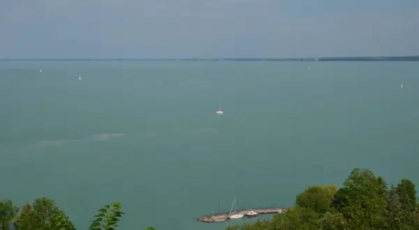 Widok na Balaton z Tihany. Żaglówki na turkusowej wodzie, molo z łodziami. Tihany atrakcje zachwycają.
