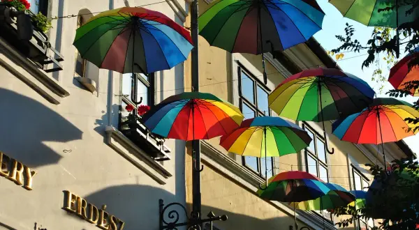 Kolorowe parasole unoszą się nad ulicą, tworząc radosną atmosferę. To jedna z urokliwych szentendre atrakcji, która przyciąga wzrok.