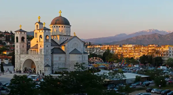 Podgorica atrakcje: monumentalna cerkiew i wesołe miasteczko w blasku zachodzącego słońca.