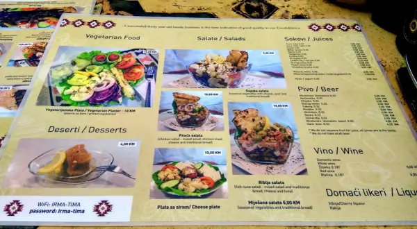 Menu z kuchnią bośniacką: wegetariański talerz, sałatki (w tym szopska), desery, piwo i wino.