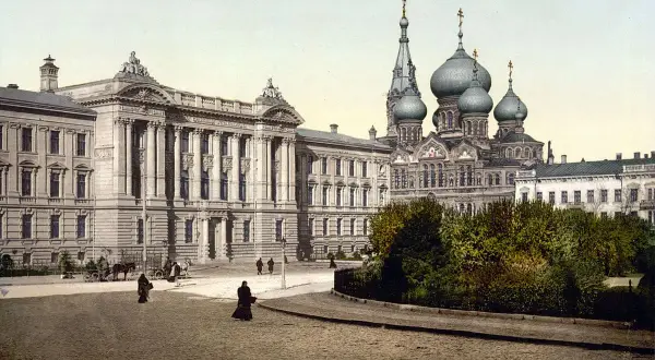 Dawne budynki i cerkiew na brukowanym placu, świadczące o tym, gdzie leży Odessa. Ludzie spacerują, a powozy stoją.