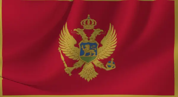 Flaga Czarnogóry z dwugłowym orłem. W tym kraju obowiązuje euro jako waluta, a język urzędowy to czarnogórski.