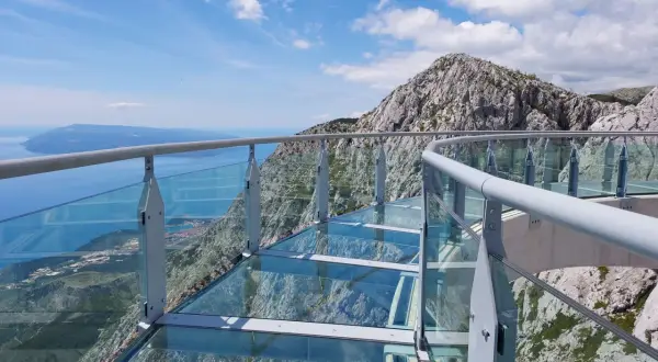 Szklana platforma widokowa z metalową balustradą, z której roztacza się zapierający dech w piersiach widok na morze i góry. To idealne miejsce na spacer po makarska trasa.