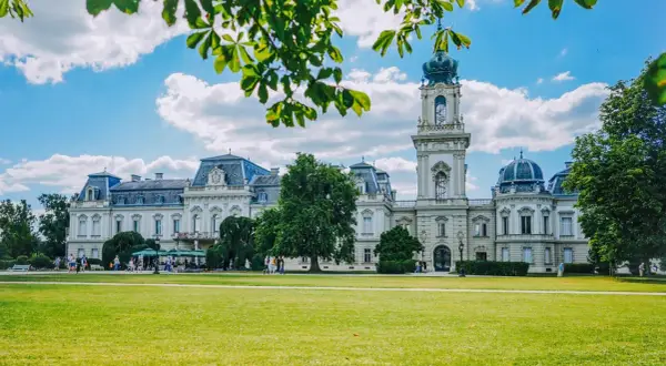 Pałac Festetics w Keszthely, jedna z głównych atrakcji, otoczony zielonym parkiem i błękitnym niebem.