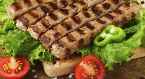 Grillowane cevapcici na sałacie z pomidorami i papryką. Idealny przepis na letnie grillowanie.