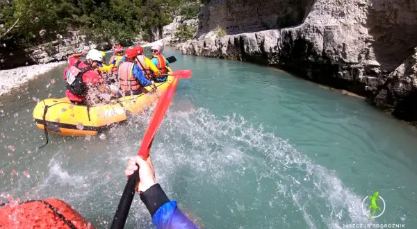 Rafting w malowniczym kanionie w Albanii. Grupa turystów w żółtej łodzi pokonuje rwący nurt rzeki, otoczeni skalnymi ścianami.
