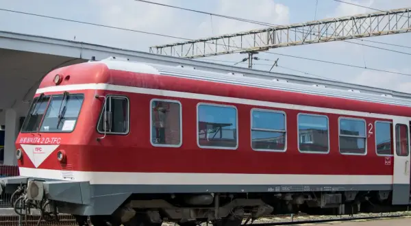 Czerwono-biały pociąg stoi na torach, gotowy do podróży. Czy to właśnie ten pociąg do Bułgarii?