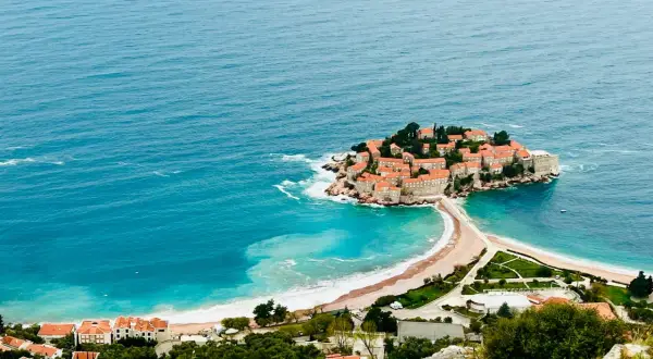 Wyspa Sveti Stefan, znana z pięknych budva plaże, połączona z lądem piaszczystą mierzeją.