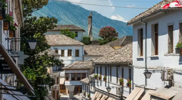 Kamienne dachy i białe domy w Gjirokastrze, Albania. W tle góry, idealne na jesienny spacer.