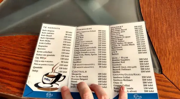 Menu z Albanii: ceny alkoholi. Widoczne są ceny whisky, ginu, rumu, grappy, ouzo i raki.
