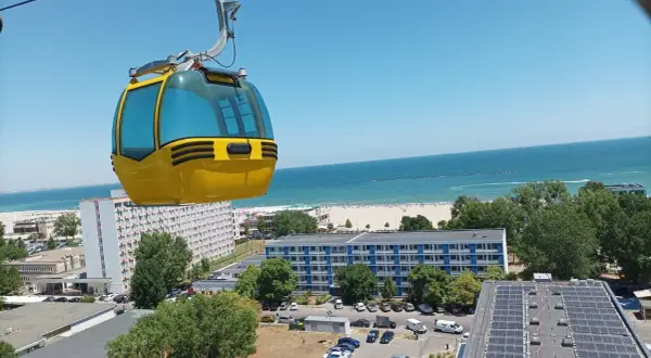 Żółta kolejka linowa nad kurortem z widokiem na piękne **konstanca plaże** i błękitne morze.