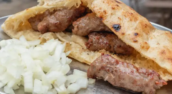 Pyszne cevapcici w bułce, jak u Makłowicza, z dużą ilością cebulki.