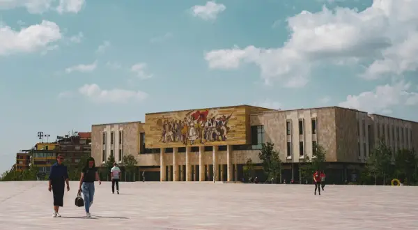 Plac Skanderbega w Tiranie, z monumentalnym budynkiem i mozaiką. Idealne miejsce, by zacząć odkrywać, co warto zobaczyć w Tiranie i okolicy.