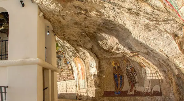 W skalnych niszach monasteru Ostrog widnieją mozaiki świętych. Biała architektura kontrastuje z surową skałą.